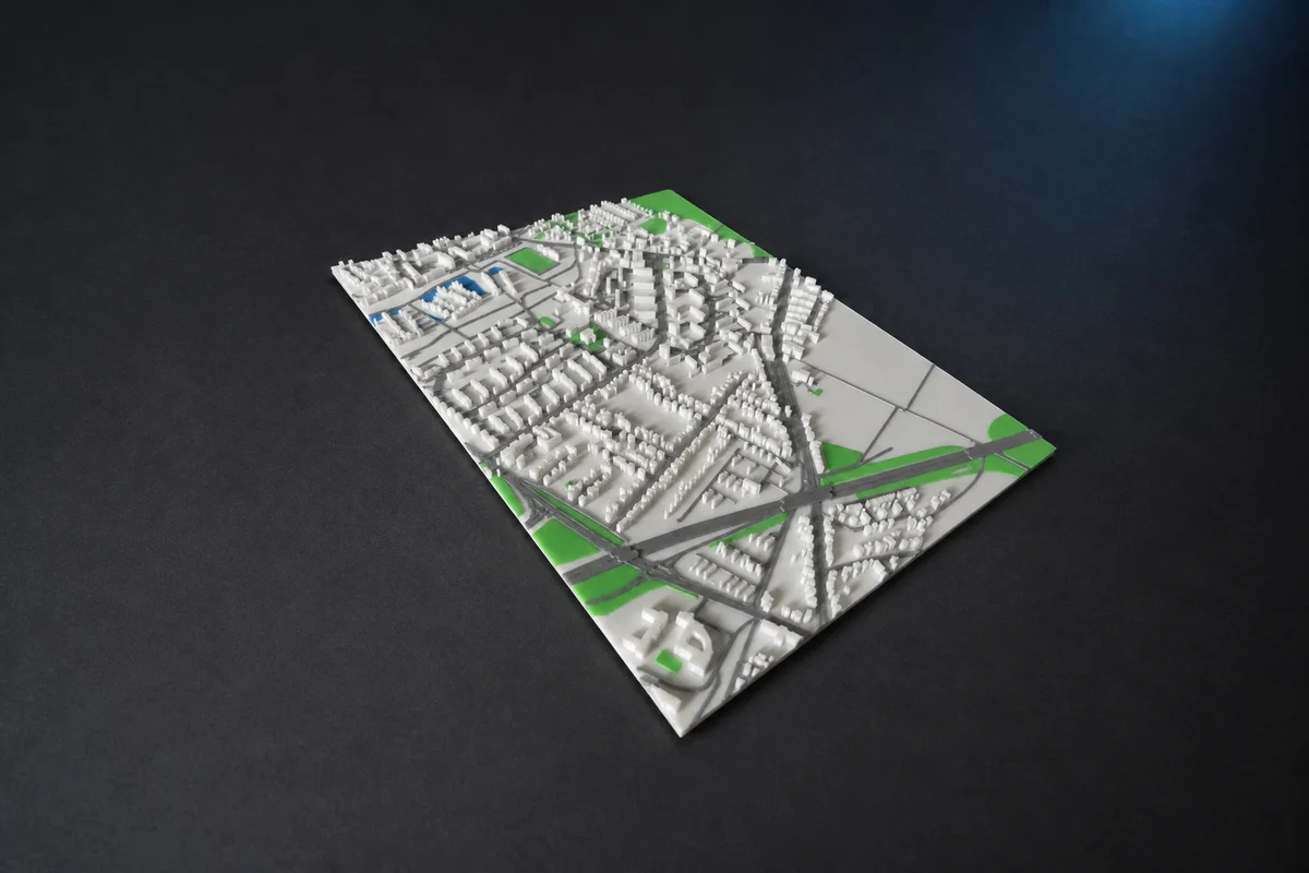 KI-generierte Formatadaption eines echten 3DZelle Produktfotos: mehrfarbig gedruckte 3D-Stadtkarte mit weißen Gebäuden, grauen Straßen, Grünflächen und Gewässern